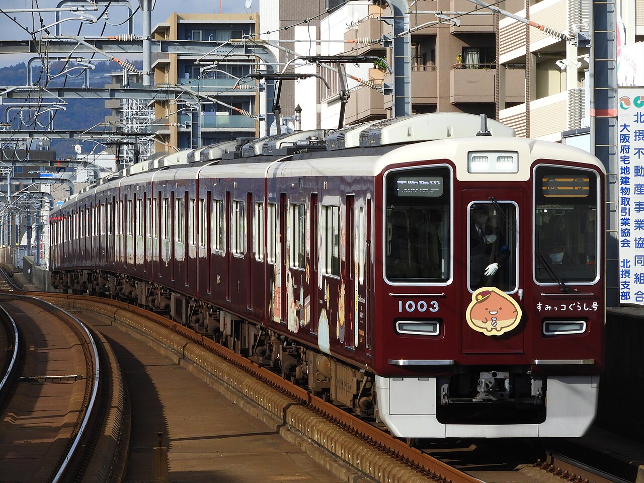A Hankyu 1000 series set 1003F in 'Sumikko Gurashi' wrapping, on an Express to Osaka-Umeda, at Okamachi Station on the Takarazuka Main Line.